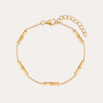 The Bamboo Chain Bracelet in Gold features a bamboo-inspired design with small cylindrical segments on a fine chain, 18k gold plating, an adjustable extension, and a lobster clasp closure.