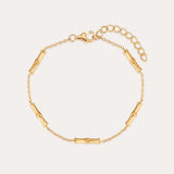 The Bamboo Chain Bracelet in Gold features a bamboo-inspired design with small cylindrical segments on a fine chain, 18k gold plating, an adjustable extension, and a lobster clasp closure.