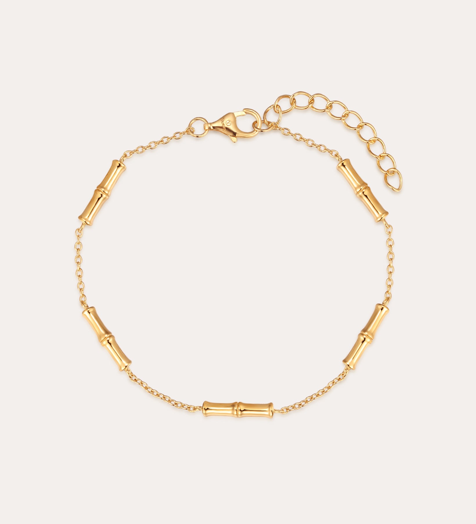 The Bamboo Chain Bracelet in Gold features a bamboo-inspired design with small cylindrical segments on a fine chain, 18k gold plating, an adjustable extension, and a lobster clasp closure.