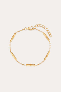 The Bamboo Chain Bracelet in Gold features a bamboo-inspired design with small cylindrical segments on a fine chain, 18k gold plating, an adjustable extension, and a lobster clasp closure.