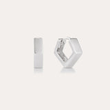 The Judith Hexagon Angular Huggies in Silver, featuring a chunky geometric design, are shown on a plain light background—one upright and one open to reveal the clasp. Perfect for stacking earring looks.