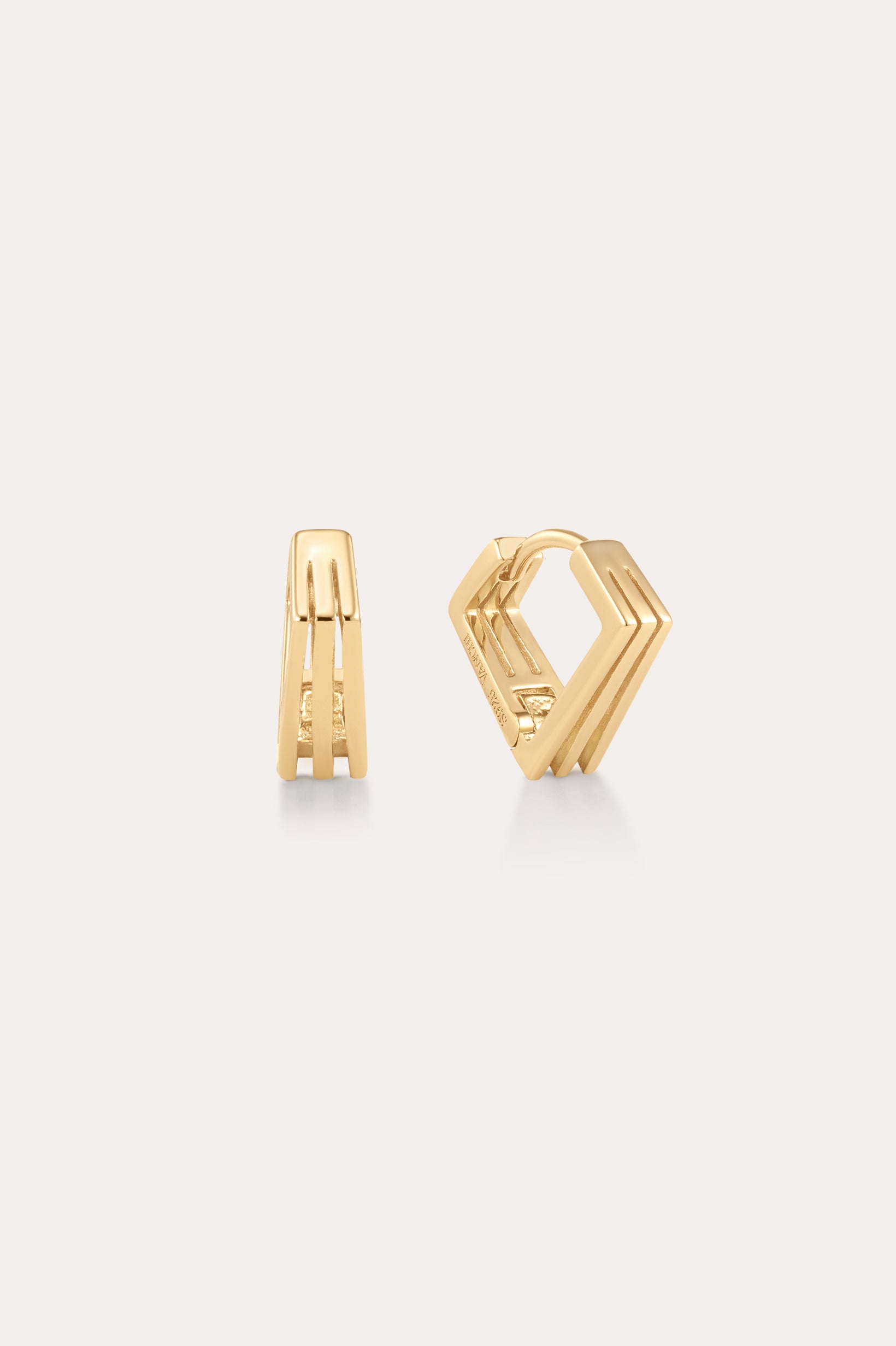 The Juliet Angular Huggies in Gold, featuring a modern geometric design with parallel lines and angular edges, are displayed on a light neutral background—perfect for fans of stylish gold huggies.