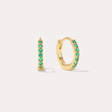 The Kiki Crystal Huggie Earrings in 18k Gold Plated/Green feature a row of green crystals on each earring, with one shown from the side and one from the front—versatile, stylish options for daily wear.