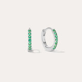 The Kiki Crystal Huggie Earrings in Sterling Silver/Green are displayed on a white background, with one earring facing forward and the other shown from the side.