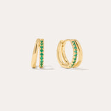 The Kira Crystal Double Hoop Huggies in Gold/Green are small earrings featuring a row of shimmering gemstones on the front, displayed against a plain light background.