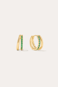 The Kira Crystal Double Hoop Huggies in Gold/Green are small earrings featuring a row of shimmering gemstones on the front, displayed against a plain light background.