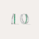 The Kira Crystal Double Hoop Huggies in Sterling Silver/Green feature a row of green gemstones along the front and are displayed against a plain white background.