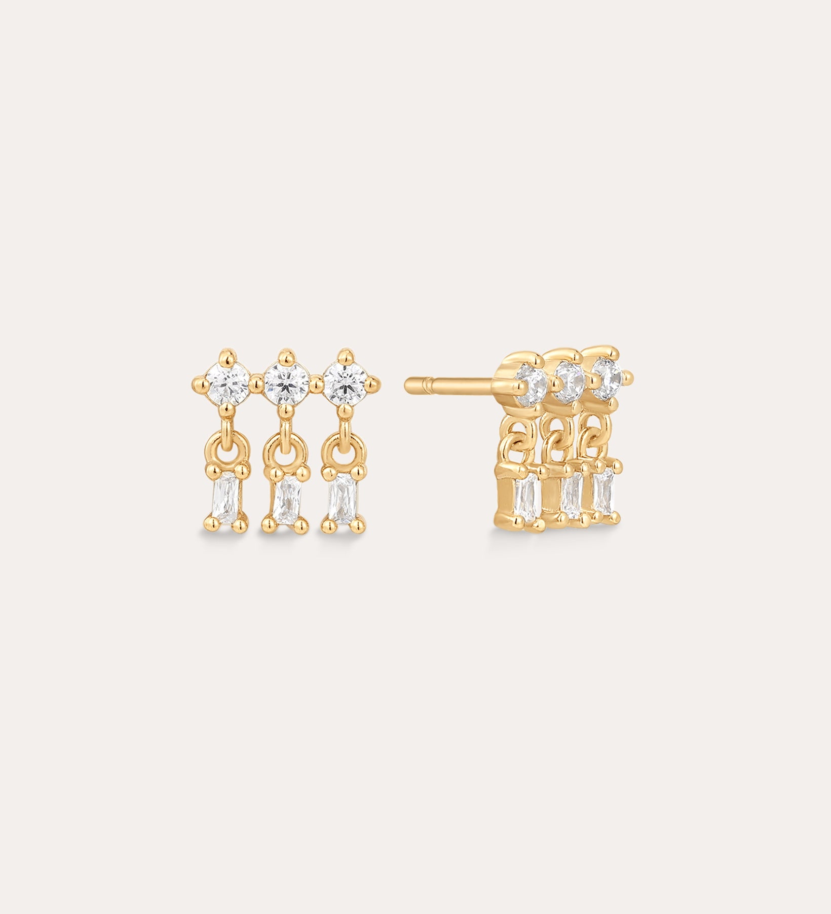 The Lexi Crystal Studs Earrings in Gold feature three geometric rows of small rectangular cubic zirconia, each dangling from a round top gemstone, for an elegant and modern look.