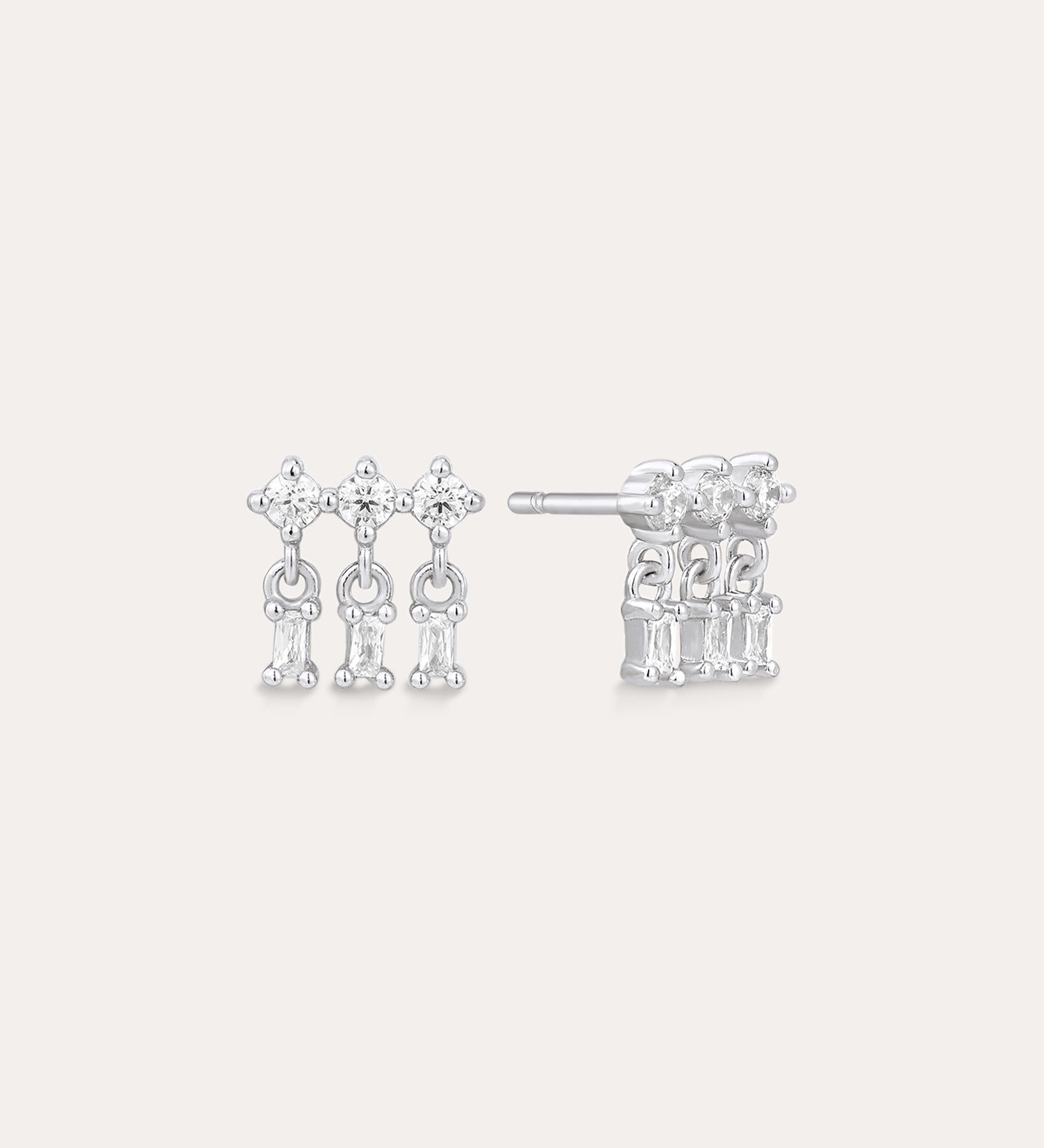 The Lexi Crystal Studs Earrings in Silver showcase three vertical rows of sparkling cubic zirconia in a geometric design, displayed on a neutral background.