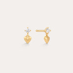 The Lilian Crystal Heart Studs Earrings in Gold feature a small gold heart charm dangling below a sparkling round crystal, displayed on a plain light background.