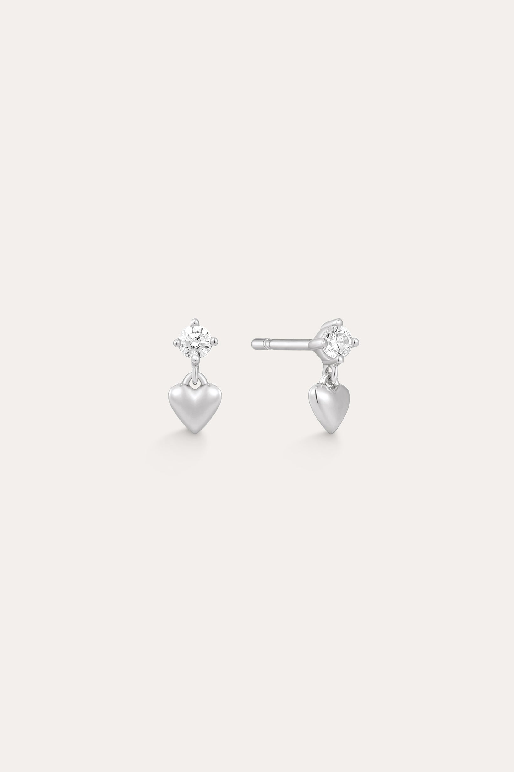 The Lilian Crystal Heart Studs Earrings in Silver feature a sparkling star-shaped gemstone above a dangling silver heart charm—perfect dainty earrings for any occasion.