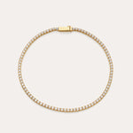 The Lumi Tennis Bracelet in Gold features small, closely set cubic zirconia along its length and a rectangular clasp engraved with VANCHI, beautifully displayed on a simple, light background.