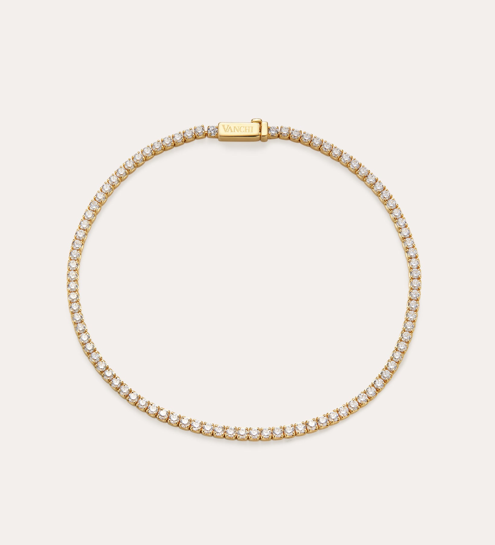 The Lumi Tennis Bracelet in Gold features small, closely set cubic zirconia along its length and a rectangular clasp engraved with VANCHI, beautifully displayed on a simple, light background.