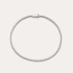 The Lumi Tennis Bracelet in Silver features a single row of sparkling cubic zirconia on a slim sterling silver band with a rectangular clasp, elegantly displayed against a plain, light background.