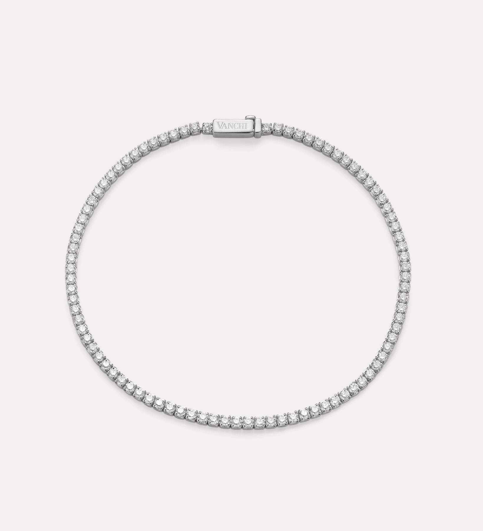 The Lumi Tennis Bracelet in Silver features a single row of sparkling cubic zirconia on a slim sterling silver band with a rectangular clasp, elegantly displayed against a plain, light background.
