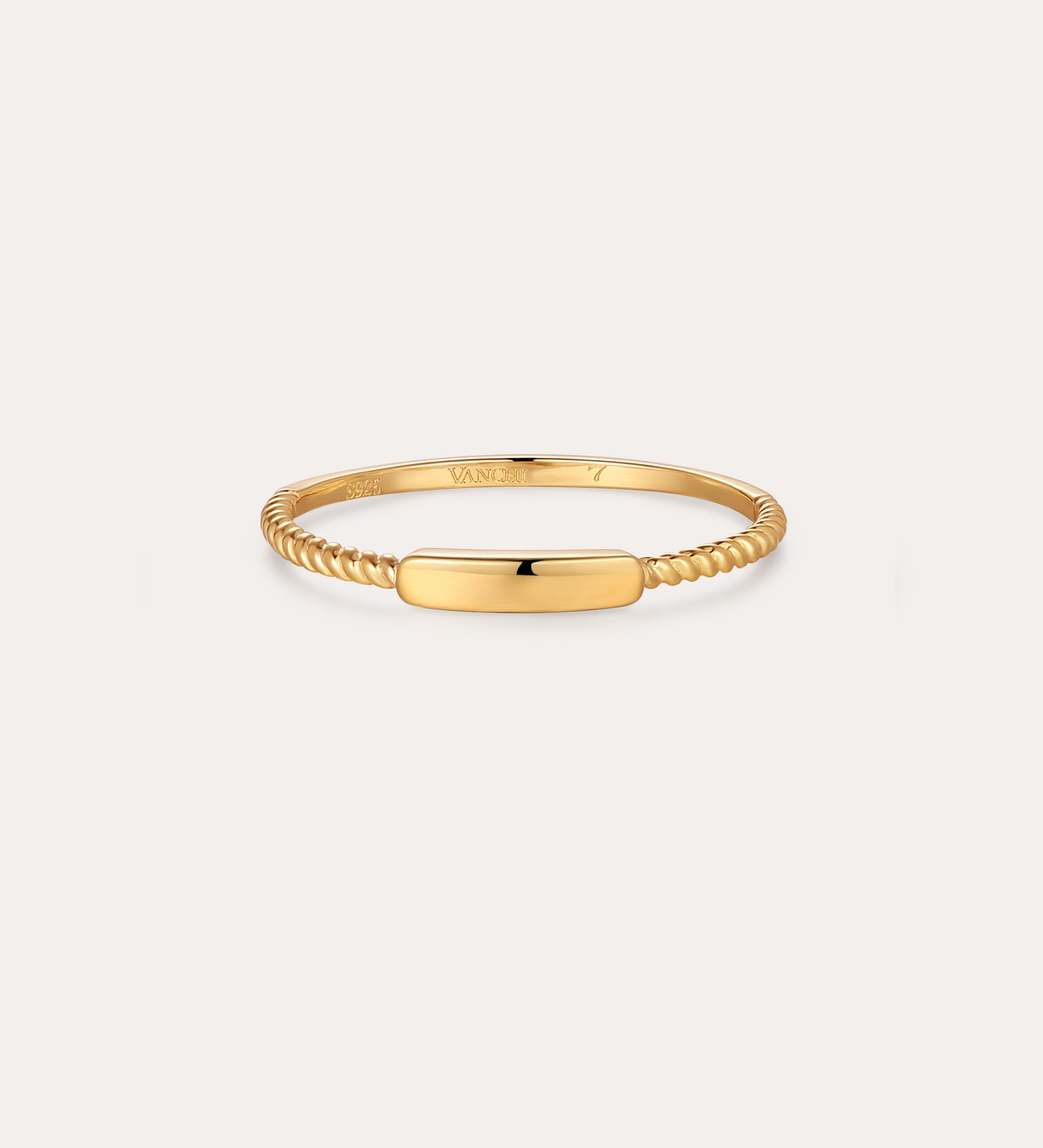The Lya Horizontal Bar Stacking Ring in Gold features a sleek rectangular plate atop a twisted band, perfect for wearing solo or stacked with other rings. Shown against a simple light background.