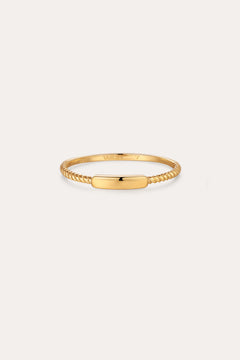 The Lya Horizontal Bar Stacking Ring in Gold features a sleek rectangular plate atop a twisted band, perfect for wearing solo or stacked with other rings. Shown against a simple light background.