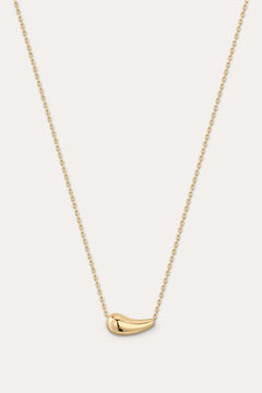 Gold necklace with a small pendant on a light gray background