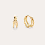 The Mae Twist Double Huggie Earrings in Gold, featuring a delicate twisted rope design, are displayed against a plain, light background.