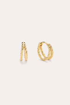 The Mae Twist Double Huggie Earrings in Gold, featuring a delicate twisted rope design, are displayed against a plain, light background.