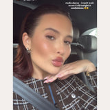 A young woman with slicked-back brown hair takes a car selfie, wearing a plaid top and Esther Square Hoop Stud Earrings in Silver. Text above her reads, “radio dayyy ·· I can’t wait to see y’all tonight @ confessions.”.