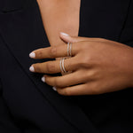 A person with medium skin tone, neatly manicured nails, and light polish wears a black blazer and showcases two delicate sterling silver rings, including the Molten Crystal Double Band Ring in Silver set with small diamonds.