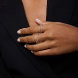 A person with medium skin tone, neatly manicured nails, and light polish wears a black blazer and showcases two delicate sterling silver rings, including the Molten Crystal Double Band Ring in Silver set with small diamonds.