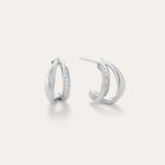 Nadine Pavé Twisted Stud Earrings in Silver feature lightweight, asymmetrical silver hoops with a row of sparkling stones along the inner curve, displayed on a plain white background.
