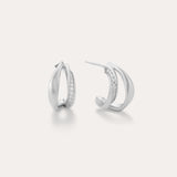 Nadine Pavé Twisted Stud Earrings in Silver feature lightweight, asymmetrical silver hoops with a row of sparkling stones along the inner curve, displayed on a plain white background.