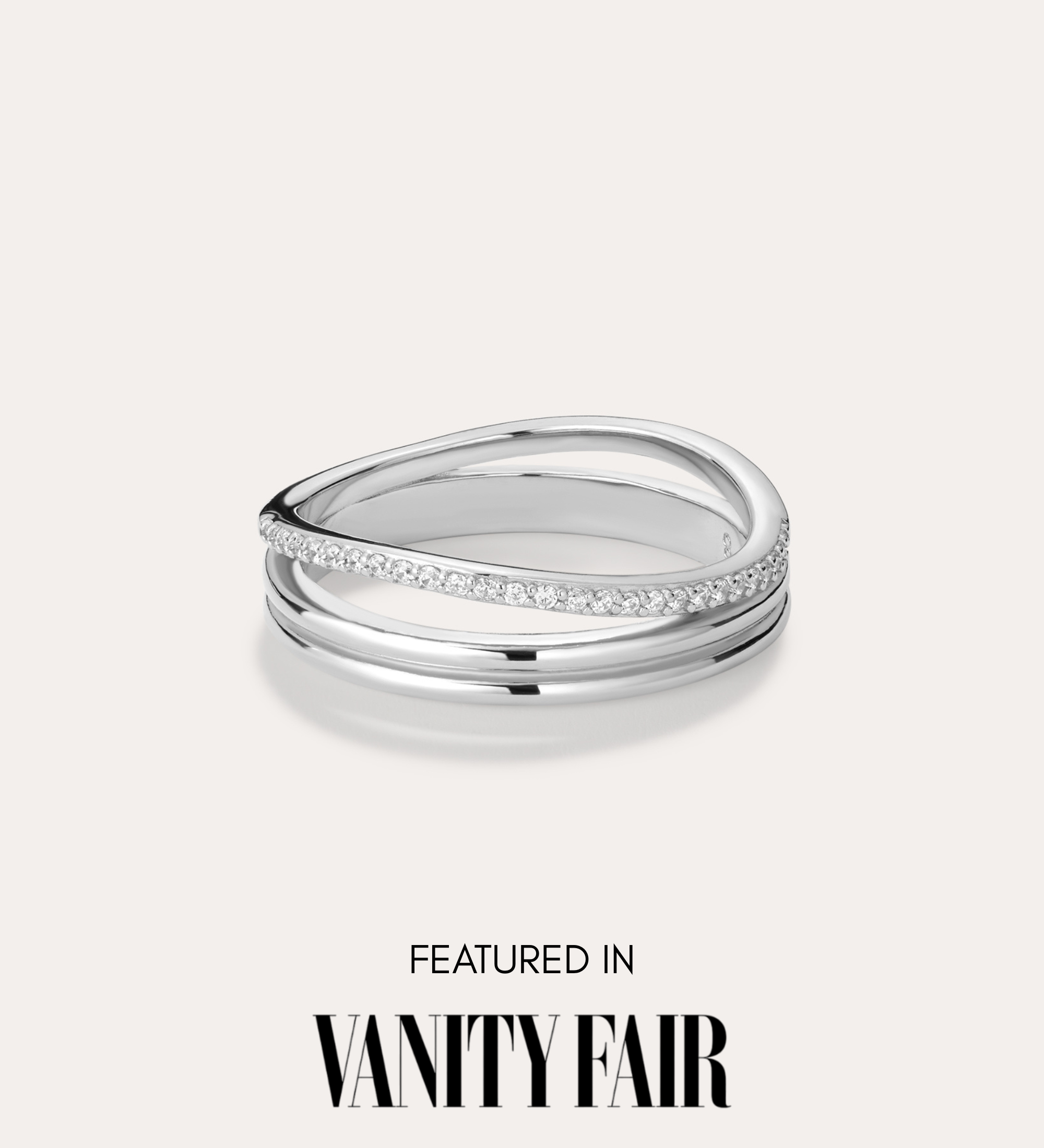 The Noor Pavé Triple Band Ring in Silver, featuring a sleek row of small diamonds, sits against a light background. Below the ring, bold black text reads: Featured in Vanity Fair.