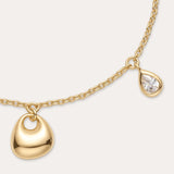 The Nora Double Pendant Bracelet in Gold features a small gold heart charm and a teardrop-shaped cubic zirconia, finished with an adjustable clasp and extension chain.