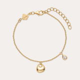 The Nora Double Pendant Bracelet in Gold features an adjustable clasp, a gold heart charm, and a teardrop-shaped cubic zirconia pendant for subtle sparkle.