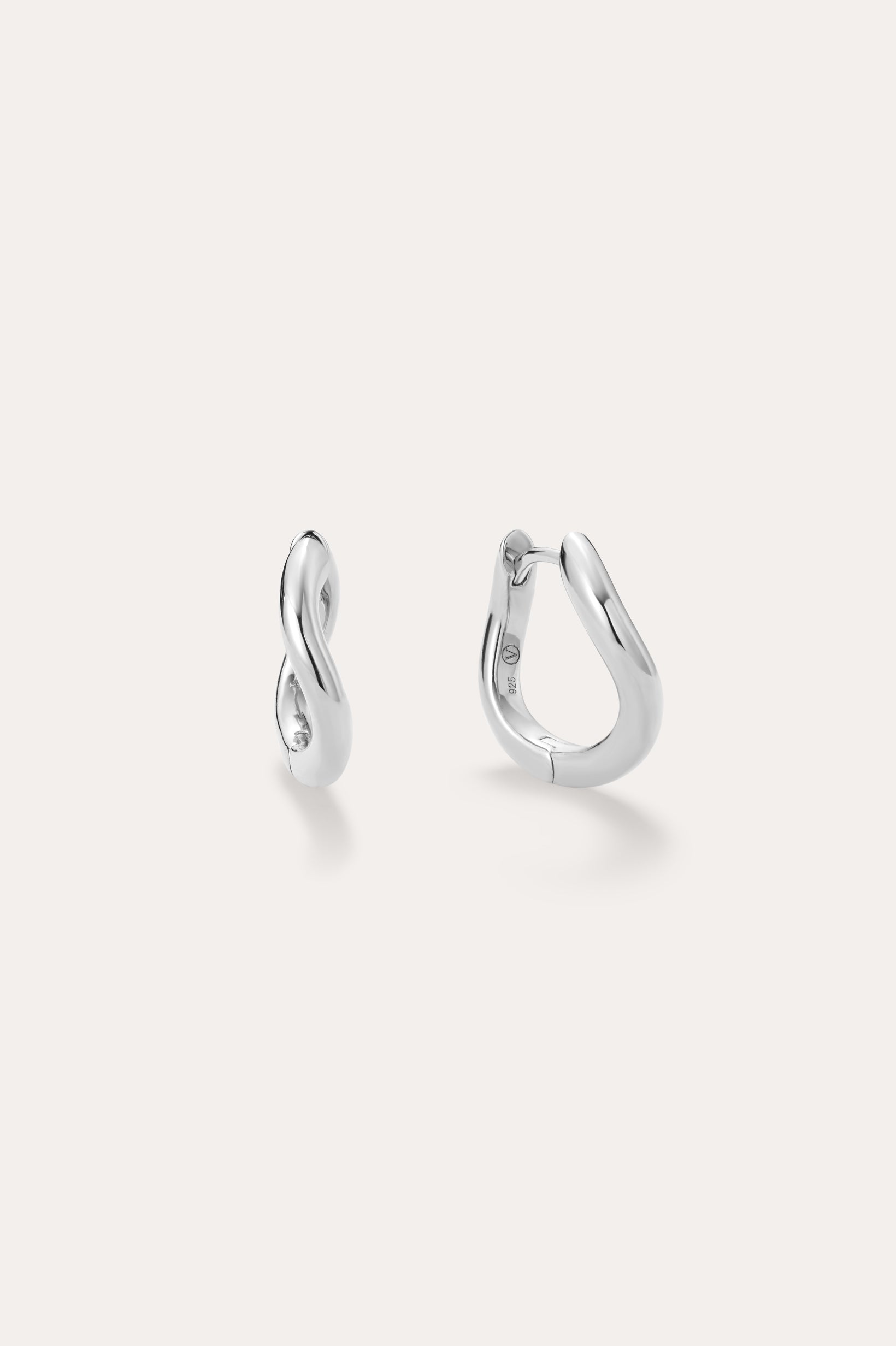 A pair of small, polished Nori Twisted Hoop Earrings in Silver with an infinity-like twist design, displayed on a light background. One sterling silver hoop faces front; the other is sideways to show the clasp.