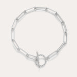 The Paperclip Toggle Bracelet in Silver features elongated oval links and a circular toggle clasp, displayed on a plain light background.
