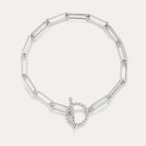 The Paperclip Toggle Bracelet in Silver features elongated oval links and a circular toggle clasp, displayed on a plain light background.