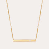 The Regina Horizontal Bar Pendant Necklace in Gold features a minimalist horizontal bar with an off-center cubic zirconia, making it perfect for lovers of simple, elegant jewelry.