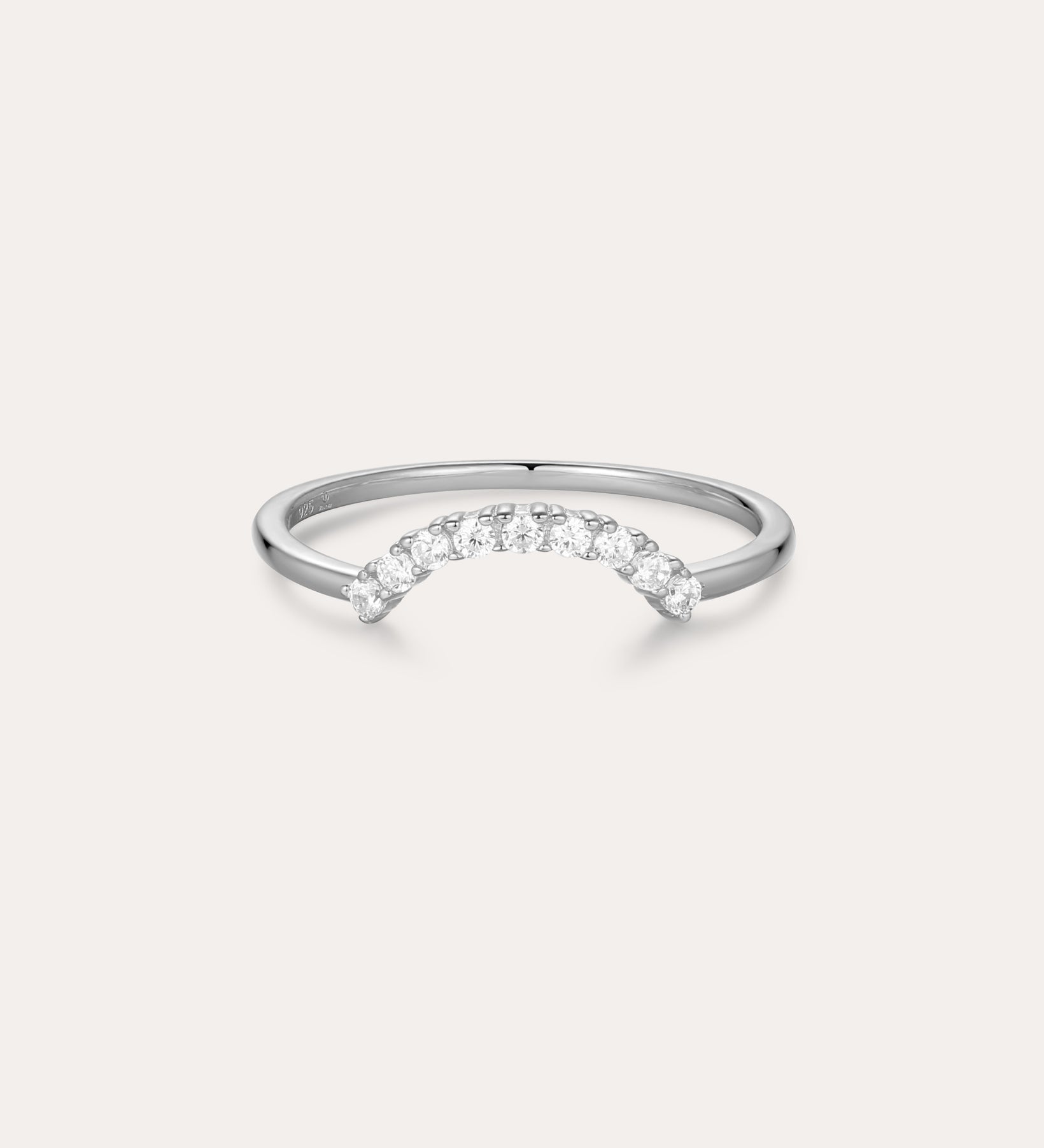 The Reine Rainbow Crystal Ring in Silver is a delicate sterling silver ring with a gentle curve, featuring a row of small, sparkling rainbow crystals set along the curved band. Its thin, minimalist design adds elegant color to any look.
