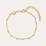 The Pia Crystal Link Bracelet in 18k Gold Plated features clusters of clear cubic zirconia, an adjustable extension chain, a lobster clasp, and a small hexagonal charm near the clasp for added elegance.