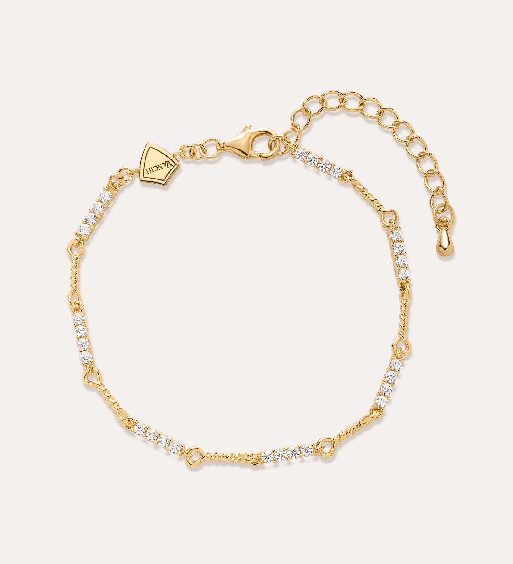 The Pia Crystal Link Bracelet in 18k Gold Plated features clusters of clear cubic zirconia, an adjustable extension chain, a lobster clasp, and a small hexagonal charm near the clasp for added elegance.