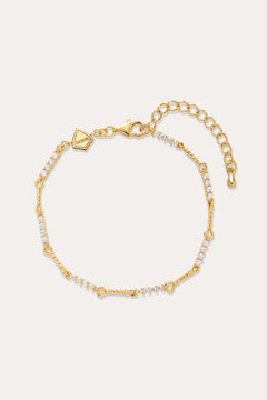 The Pia Crystal Link Bracelet in 18k Gold Plated features clusters of clear cubic zirconia, an adjustable extension chain, a lobster clasp, and a small hexagonal charm near the clasp for added elegance.