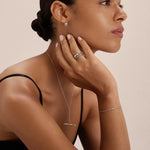 A woman with slicked-back hair wears a black sleeveless top and minimal jewelry, including the Bamboo Ring in Silver, as she thoughtfully poses with her hand on her chin against a plain background.