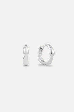 The Colette Droop Link Huggie Earrings in Silver are shown against a white background, with one earring facing front and the other from the side to display their sleek, polished, and minimalist design—ideal for everyday wear.