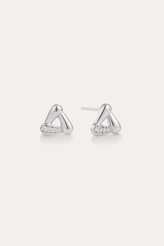 A pair of Colette Droop Link Studs in Silver, with smooth, rounded triangular shapes and small embedded cubic zirconia crystals on one side, displayed on a plain light background.