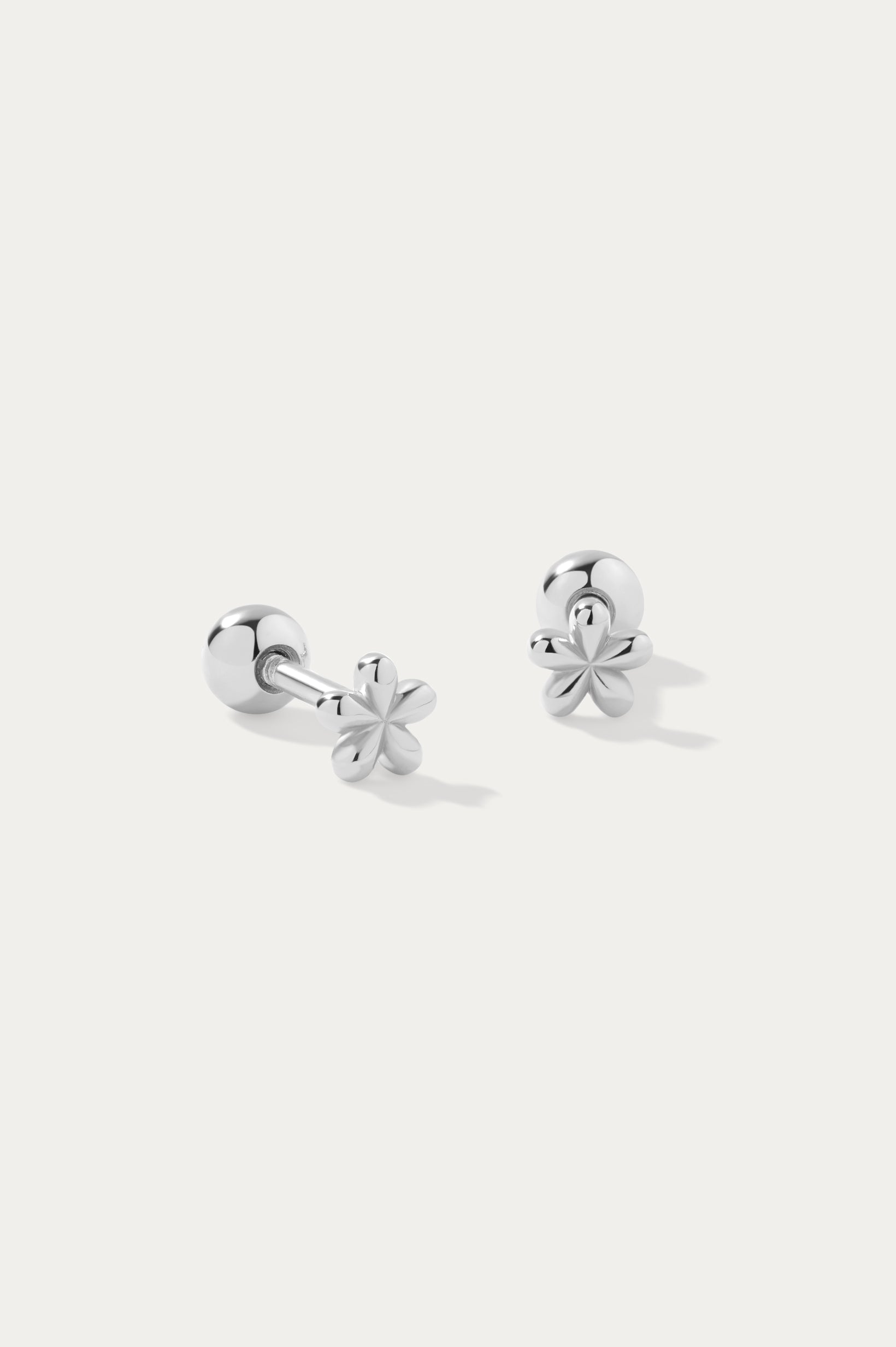 The Fleur Flower Barbell Stud Piercing in Silver features petite, cherry blossom-shaped studs, elegantly displayed on a plain white background.