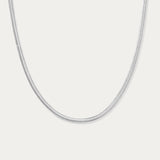 The Estelle Herringbone Chain Necklace in Silver is a sleek, minimalist chain shown against a plain white background.
