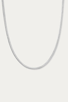 The Estelle Herringbone Chain Necklace in Silver is a sleek, minimalist chain shown against a plain white background.