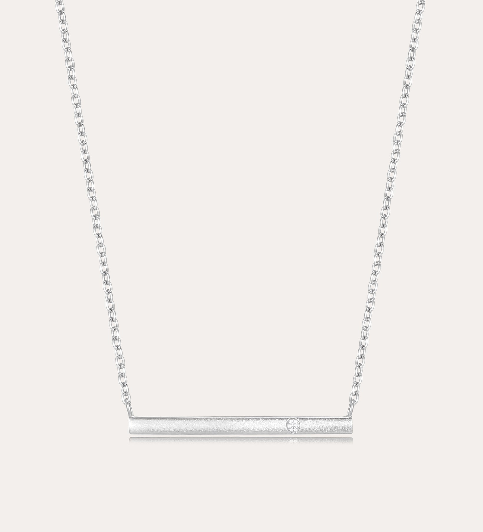 The Regina Horizontal Bar Pendant Necklace in Silver features a minimalist silver bar with a single, sparkling cubic zirconia at its center—ideal for lovers of simple, elegant jewelry.