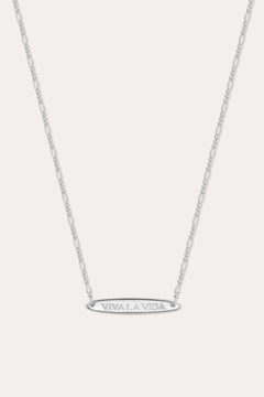 The Viva La Vida Bar Chain Necklace in Silver features a delicate, adjustable Figaro chain and an engraved oval horizontal bar pendant with VIVA LA VIDA in capitals, shown on a plain white background.