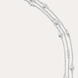 The Simone Triple Chain Layered Bracelet in Silver features three delicate sterling silver chains adorned with small round and oval disc accents, finished with a lobster clasp closure.