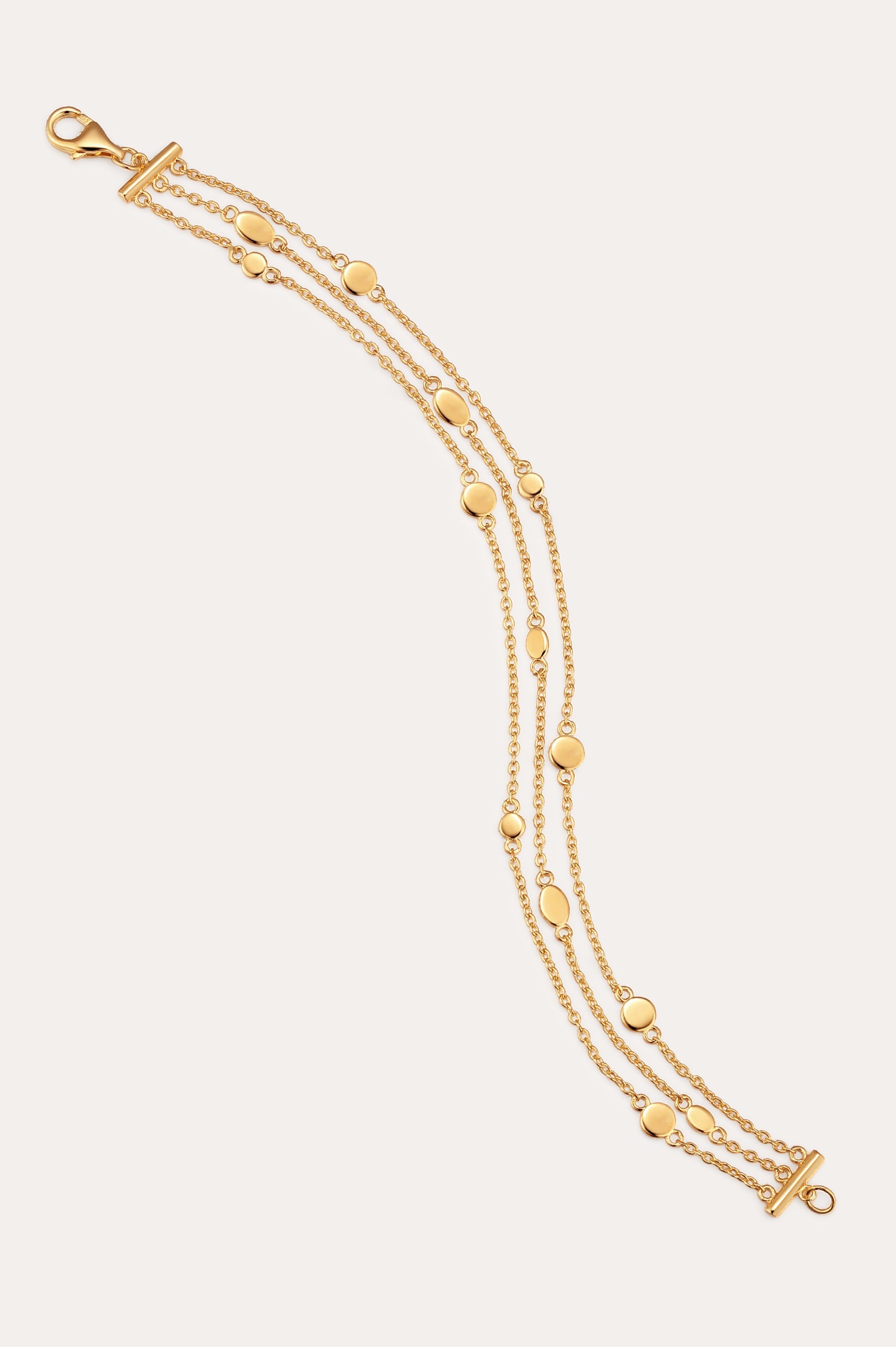 A triple layered gold bracelet with chain links and small circular embellishments, fastened with a lobster clasp.